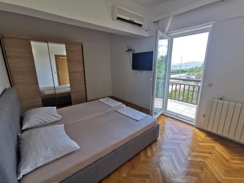 - une chambre avec un grand lit et une grande fenêtre dans l'établissement Apartment Čirko, à Kaštela