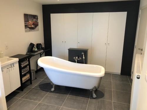 a white bath tub in a bathroom with a sink at B&B 22 in Elsegem