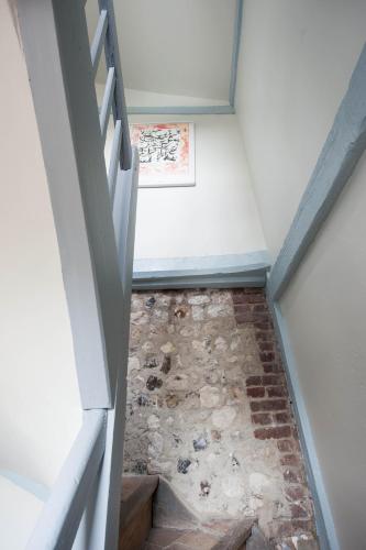an attic stairway with a stone floor and a picture at Chambres chez l'habitant Capucine in Honfleur