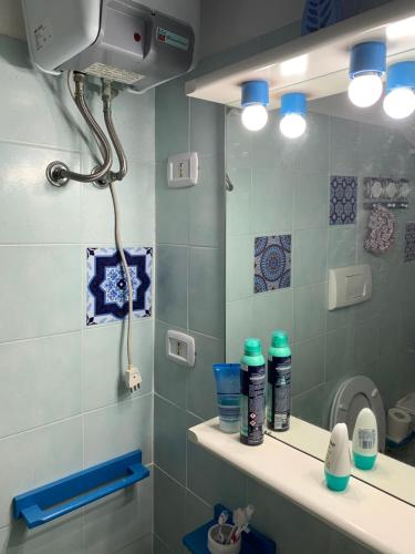 bagno con doccia e specchio di Casa accogliente a Calasetta
