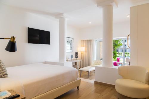 Habitación de hotel con cama y silla en Princess Family Club Bavaro - All Inclusive, en Punta Cana