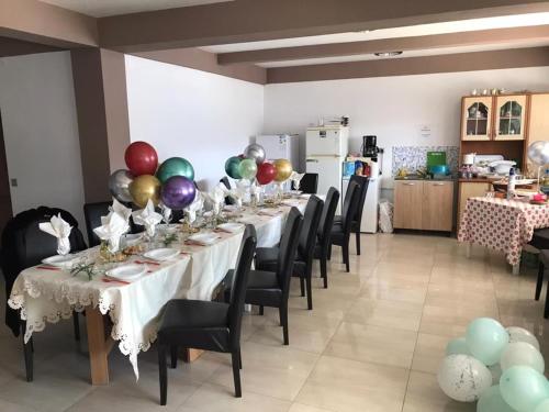 - une salle à manger avec une grande table et des ballons dans l'établissement Casa Alle, à Eşelniţa