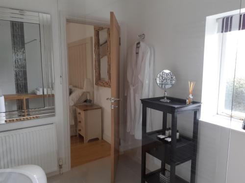 ein Badezimmer mit einem schwarzen Regal neben einer Tür in der Unterkunft The Cobblers Bed and Breakfast in Bishampton
