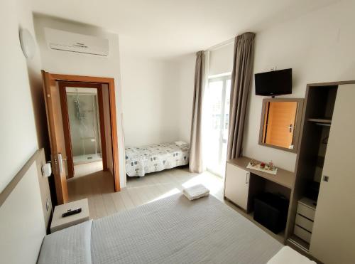 uma sala com um quarto com uma cama e um espelho em Hotel Capitano em Tortoreto Lido