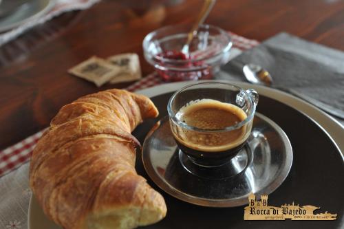 a plate with a cup of coffee and a croissant at B&B Rocca di Bajedo in Pasturo