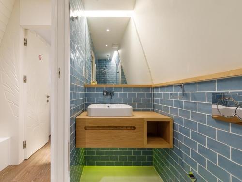 a bathroom with a sink and blue tiles at London Bridge Boutique by Viridian Apartments in London