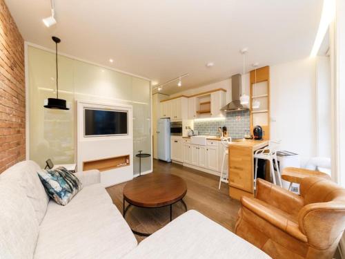 a living room with a white couch and a kitchen at London Bridge Boutique by Viridian Apartments in London