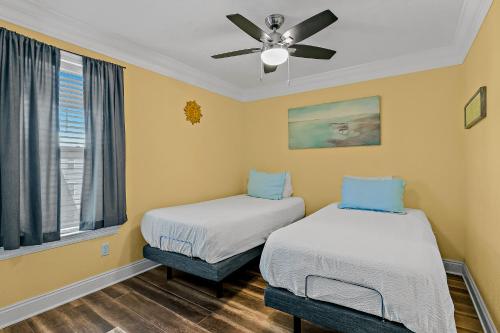 2 camas en una habitación con ventilador de techo en Hermitage, en Fort Walton Beach