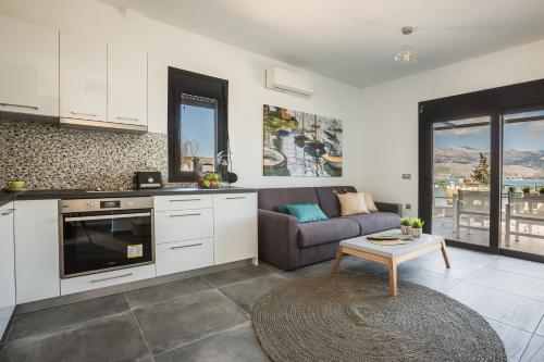 a kitchen and living room with a couch and a table at Ionian Village in Lixouri