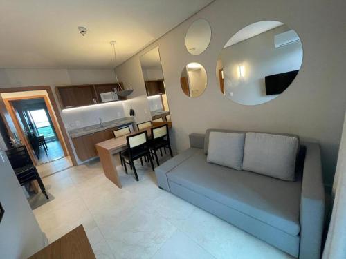 a living room with a couch and a dining room at APTO SALINAS EXCLUSIVE RESORT - 04 Hóspedes Adultos e 01 Criança até 03 anos in Salinópolis