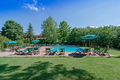Terricciola的住宿－塞維諾Il號農家樂，一组椅子和遮阳伞,位于游泳池旁