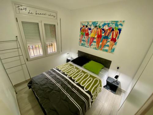 1 dormitorio con 1 cama y una pintura en la pared en Superbe Appartement , tout confort, 40 m2 + 10 m2 terrasse, en Empuriabrava