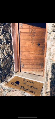 a welcome mat in front of a wooden door at Il Nuraghe del lago Coghinas in Oschiri