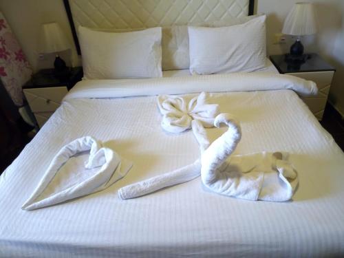 Apartment in Porto Sharm VIP في شرم الشيخ: مناشف بجعتين على سرير في غرفة الفندق