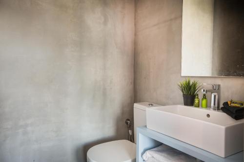 a bathroom with a white sink and a toilet at Ionian Village in Lixouri