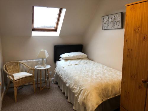 Schlafzimmer mit einem Bett, einem Tisch und einem Fenster in der Unterkunft Fairview Bed and Breakfast in Airdrie