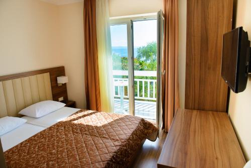 a hotel room with a bed and a balcony at Villa Gradina in Baška Voda