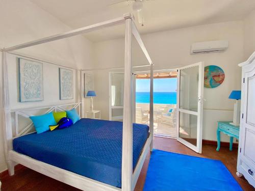 1 dormitorio con cama y vistas al océano en Beachfront House Geremeas Sardegna, en Geremèas