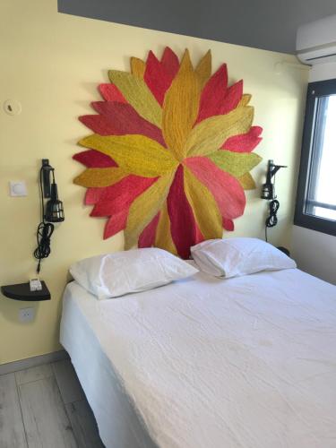 ein Schlafzimmer mit einem großen Blumenbild an der Wand in der Unterkunft Piña Colada à Manapany les bains in Manapany-les Bains