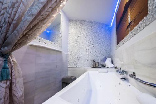 a white bathroom with a tub and a sink at Hostal La Carretera in Torrejón de Ardoz