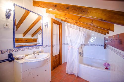 a bathroom with a sink and a tub and a mirror at Posada Rio Cubas in Cubas