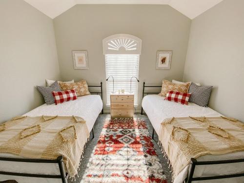 two beds in a room with a window at The Pearl: A Fully Updated 3 Bedroom Home Near ACU in Abilene