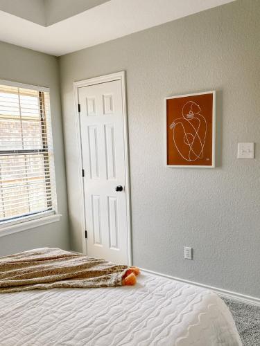 a bedroom with a bed and a picture on the wall at The Pearl: A Fully Updated 3 Bedroom Home Near ACU in Abilene
