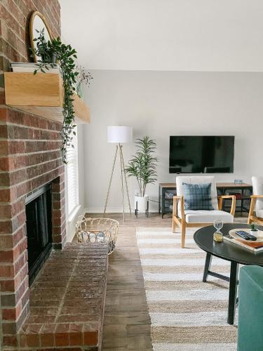 a living room with a brick fireplace at The Pearl: A Fully Updated 3 Bedroom Home Near ACU in Abilene