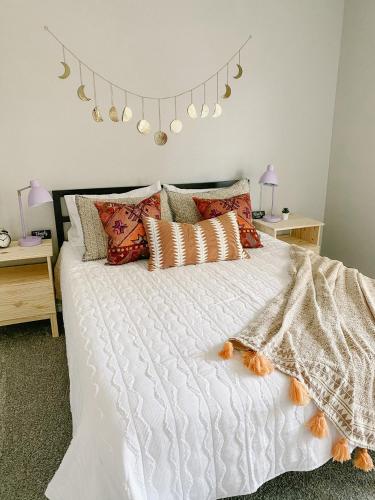 a bedroom with a white bed with orange pillows at The Pearl: A Fully Updated 3 Bedroom Home Near ACU in Abilene