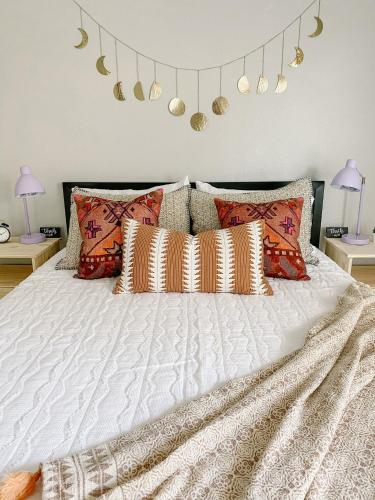 a bedroom with a white bed with pillows and lights at The Pearl: A Fully Updated 3 Bedroom Home Near ACU in Abilene
