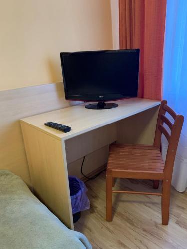 a computer desk with a monitor and a chair at Ludowa Restauracja & Noclegi in Kietrz