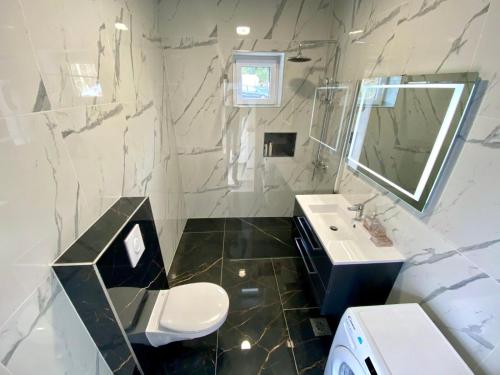 a white bathroom with a sink and a mirror at Villa Olga - Uniqe house with private beach in Ankaran