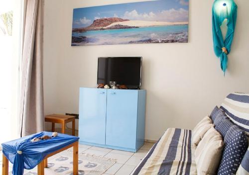 a living room with a blue cabinet and a tv at Sea view houses, Praia de Chaves, Boa Vista, Cape Verde, FREE WI-FI in Cabeçadas