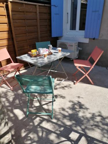 - une table avec des chaises et une table avec de la nourriture dans l'établissement MAISON DE VILLAGE, à Saint-Barthélemy-de-Vals