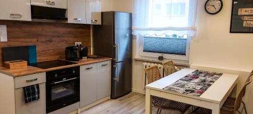 uma pequena cozinha com uma mesa e um frigorífico em Apartament Grunwaldzka em Tuchola