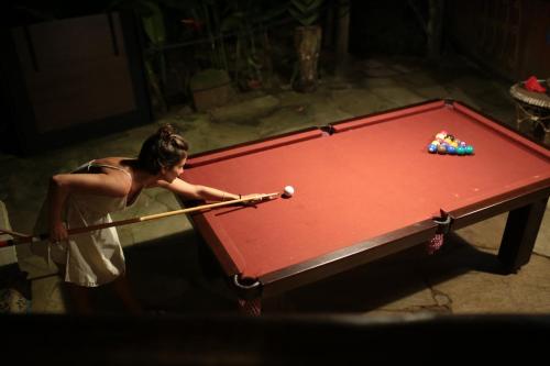 a woman playing pool on a pool table at Paraty Paradiso in Parati-Mirim