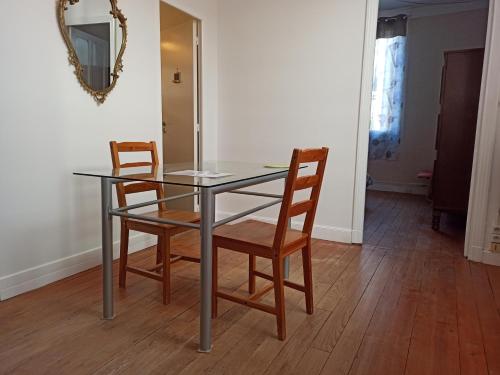 une table de salle à manger avec deux chaises et un miroir dans l'établissement T2 Toulouse Saint cyprien 40m2 indépendant, quartier sympa, 1er étage sur 2, Terrasse, à Toulouse