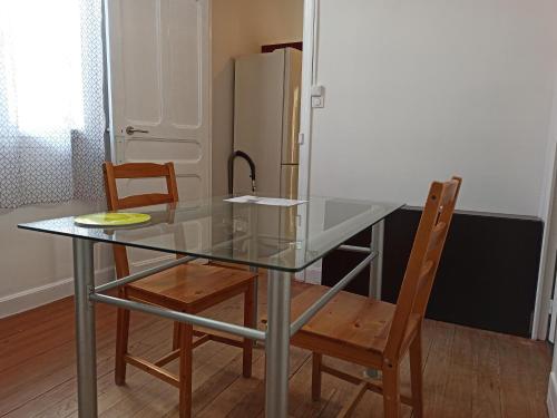 une table en verre avec deux chaises et un réfrigérateur dans l'établissement T2 Toulouse Saint cyprien 40m2 indépendant, quartier sympa, 1er étage sur 2, Terrasse, à Toulouse