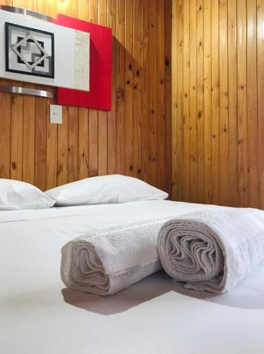 a white bed with a towel on top of it at El Pindo Iguazu in Puerto Iguazú