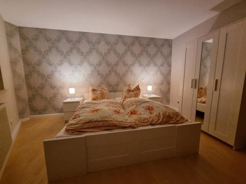 1 dormitorio con 1 cama grande y 2 mesitas de noche en Ferienwohnung Am Anger, en Diedorf