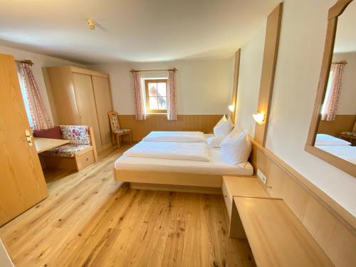 Habitación pequeña con cama y espejo. en Lindnerhof Urlaub am Bauernhof en San Lorenzo di Sebato