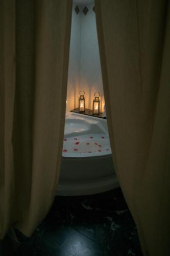 a bathroom with a bath tub with two candles in it at Residenza Kastrum in Cagliari