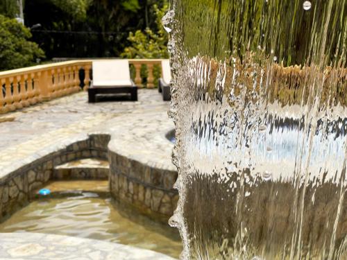 a fountain in a park with a bench in the background at Rancho San Antonio in Salento