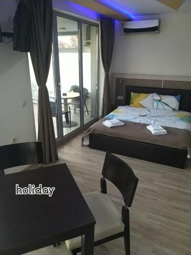 a hotel room with a bed and a table and chairs at "При братята" - Apartments & Studios in Sandanski