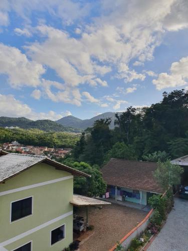 a view of a house with mountains in the background at Aconchego do Vale in Blumenau