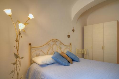 1 dormitorio con 1 cama con almohadas azules y blancas en Appartamento la Fortezza en Volterra