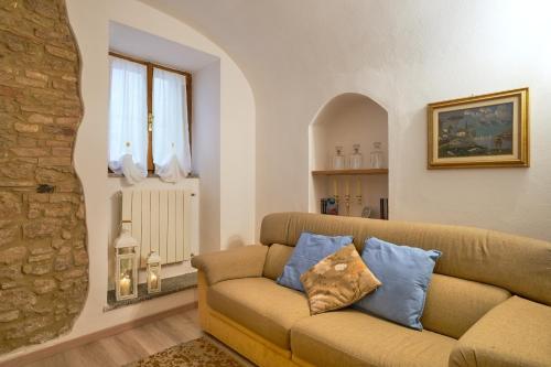 sala de estar con sofá marrón con almohadas azules en Appartamento la Fortezza en Volterra
