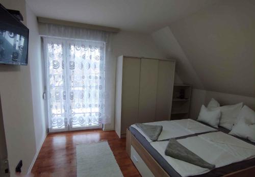 ギェネシュディアーシュにあるApartment Gyenesdias 19のベッドルーム1室(ベッド1台、大きな窓付)