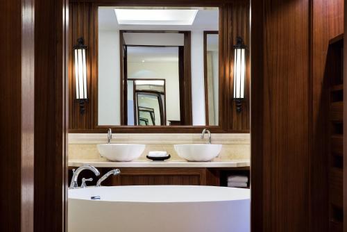 a bathroom with two sinks and a large mirror at InterContinental Xishuangbanna Resort by IHG in Jinghong