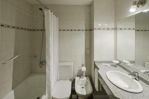 a bathroom with a toilet and a sink and a shower at Hotel Intermonti in San Martín de los Andes